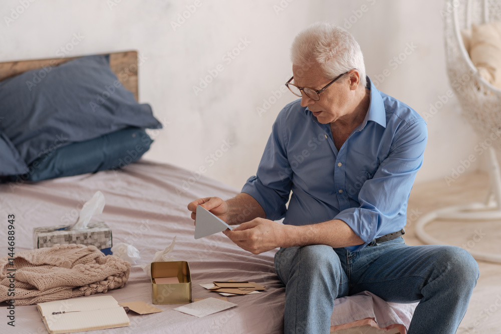 Fototapeta premium Unhappy elderly man holding an envelope