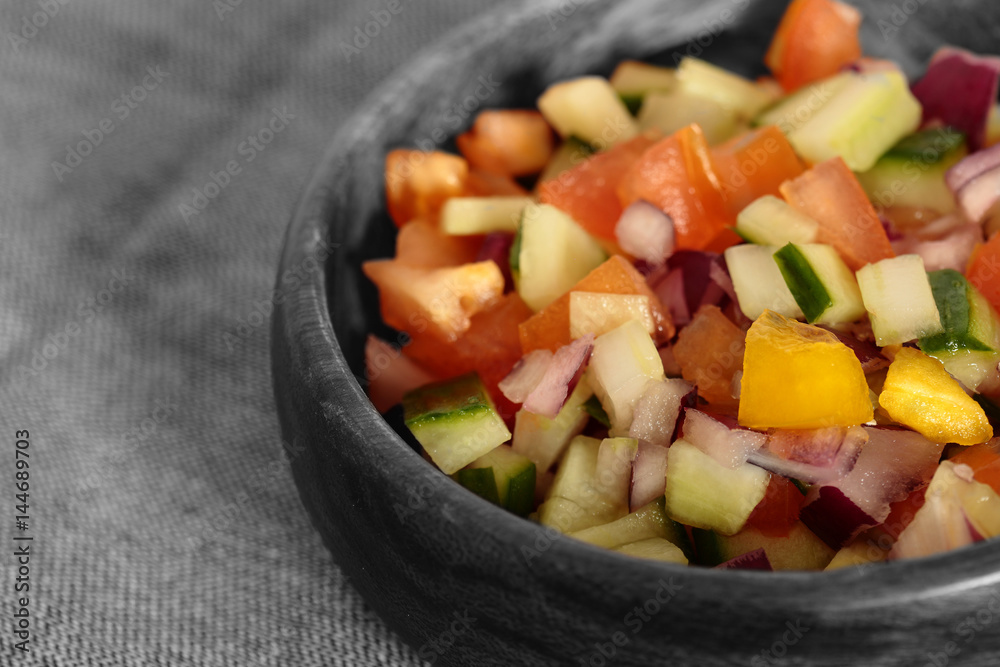 Selective colour image of a salad salsa in a wooden bowl Selective colour image of a salad salsa in a wooden bowl