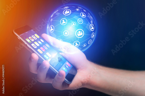Businessman holding smartphone with network globe sphere hologram going out - Technology concept