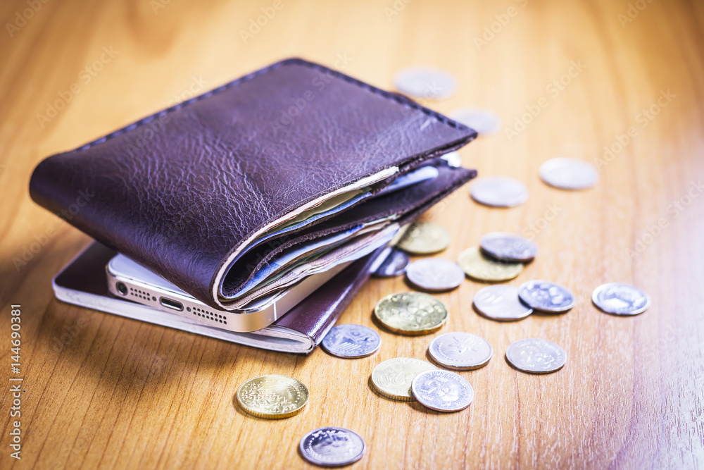Wallet with money, coin, phone and passport are on wooden table. Wallet with money, coin, phone and passport are on wooden table.