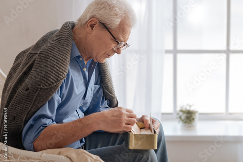 Quadro em tela Depressed aged man sitting near the window