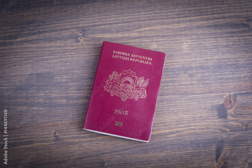 Latvian european passport on dark wood background. Latvian european passport on dark wood background.