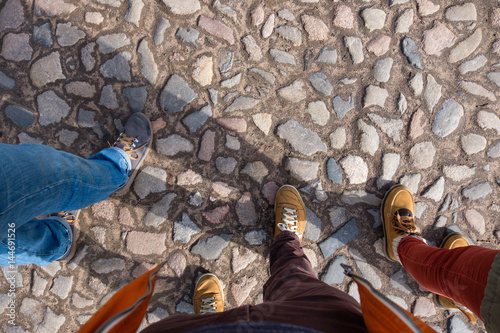 Canvas Print Three friends walk in shoes along the pavement