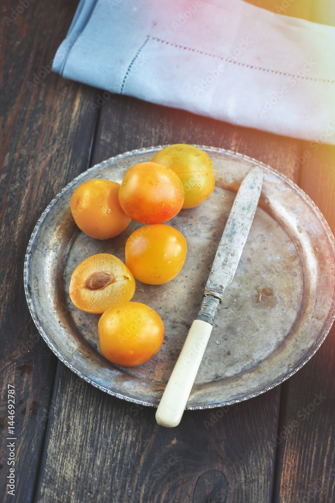Yellow mirabelle plums in rustic metal dish