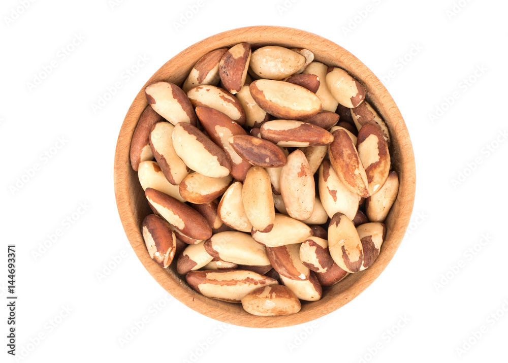 Wooden bowl filled with Brazil nut isolated white background, top view Wooden bowl filled with Brazil nut isolated white background, top view
