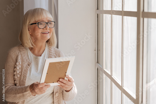 Delighted dreamy woman looking into the window