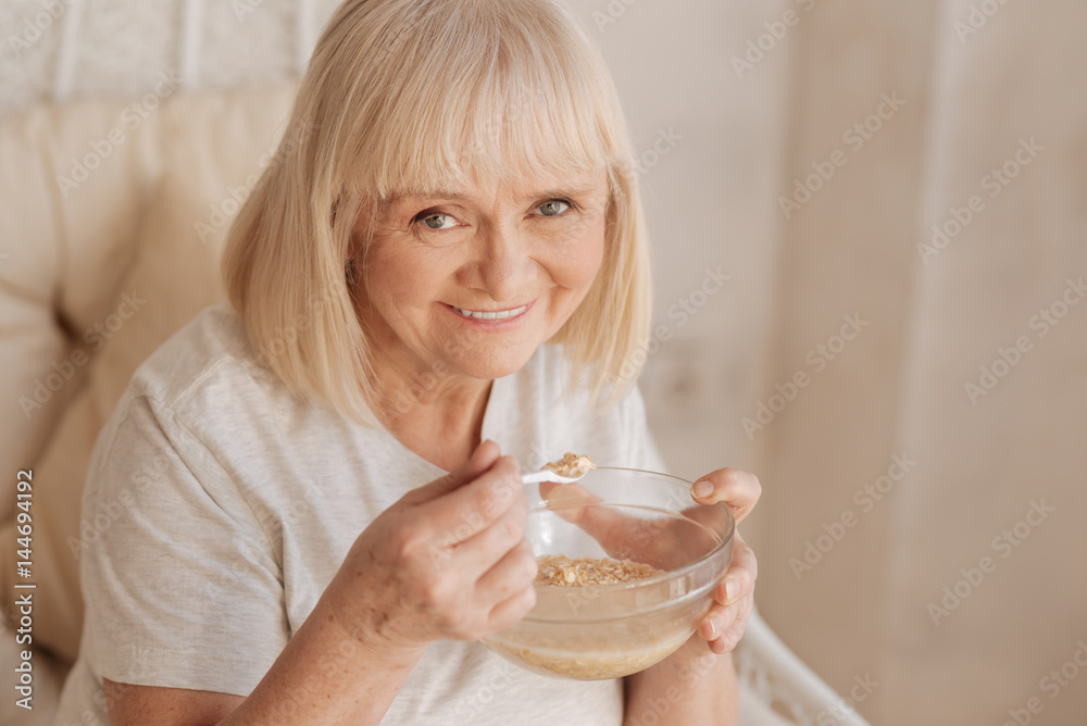 Cheerful positive woman enjoying her breakfast Cheerful positive woman enjoying her breakfast