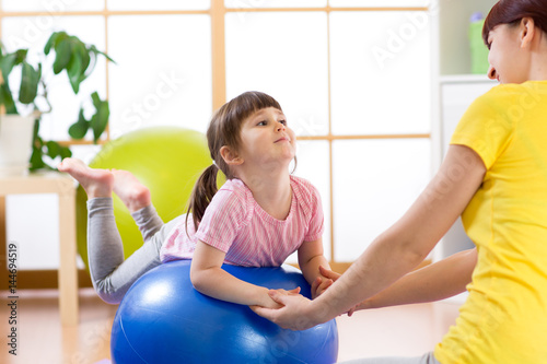 kid girl and mother do gymn...