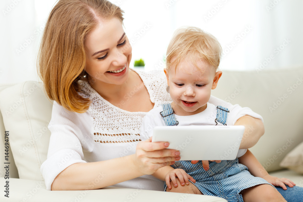Mother and baby son with a tablet computer at home Mother and baby son with a tablet computer at home