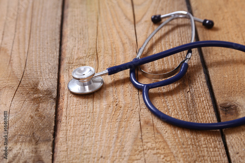 Closeup of a medical stethoscope, isolated on wooden background