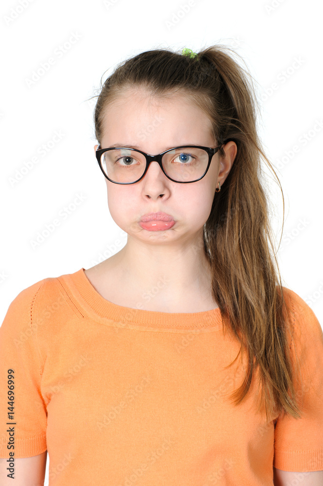 Portrait of a teenage girl with an offended grimace on her face.
