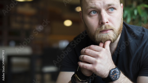 young man using sittnig in coffee shop