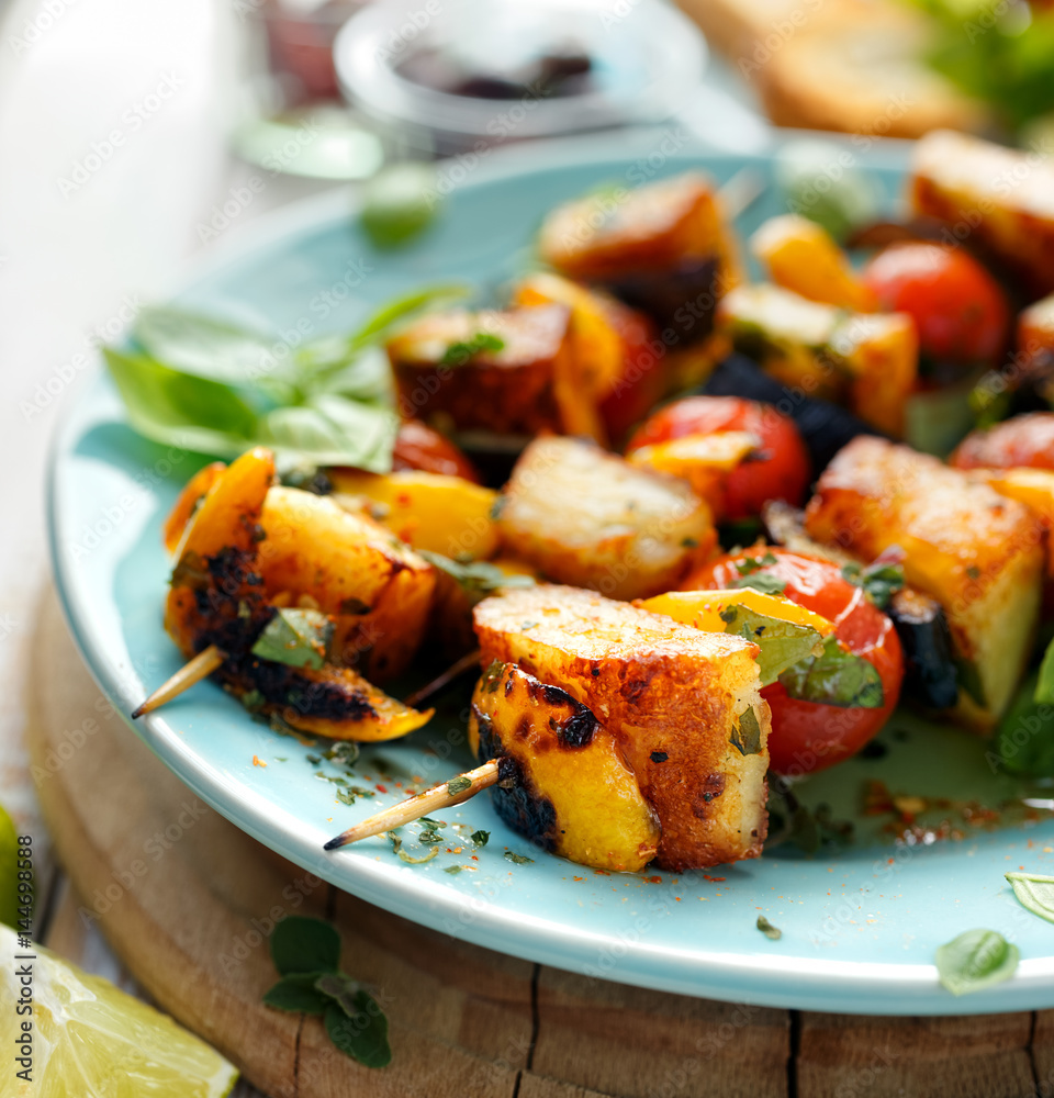 Grilled skewers of halloumi cheese and vegetables with addition aromatic herbs