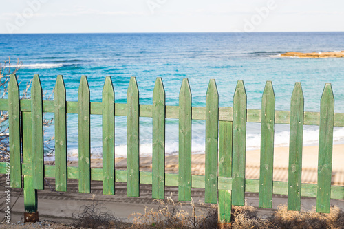 Green wooden fence on the beach