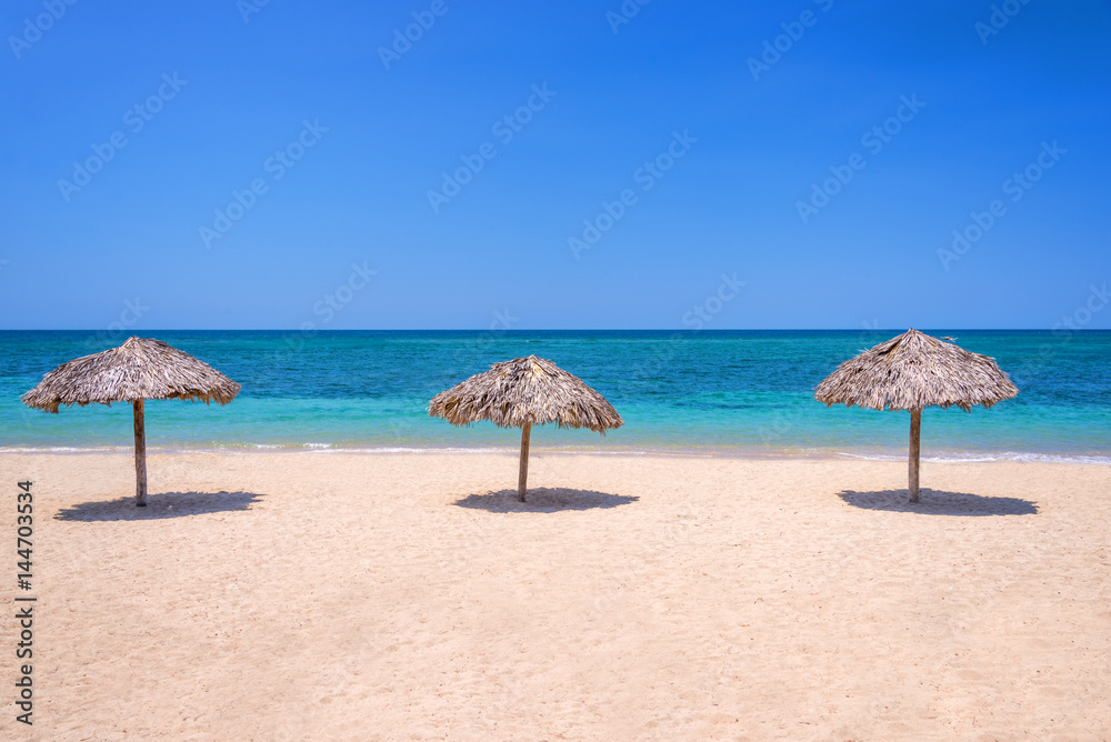 Straw umbrellas on a beautiful tropical beach