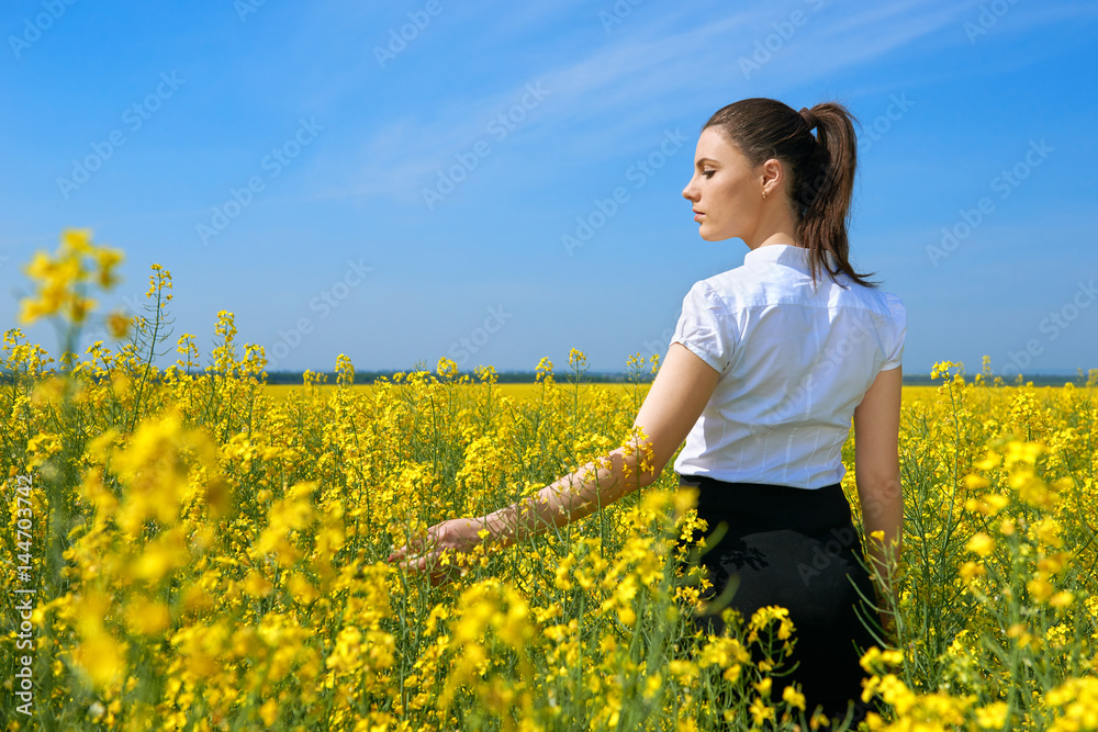 Girl in yellow flower field, beautiful spring landscape, bright sunny day, rapeseed Girl in yellow flower field, beautiful spring landscape, bright sunny day, rapeseed