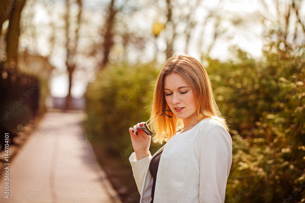 Outdoor portrait of young beautiful woman posing on street with sunglasses in sunny day. Female fashion. City lifestyle. Outdoor portrait of young beautiful woman posing on street with sunglasses in sunny day. Female fashion. City lifestyle.