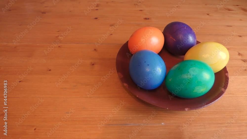 Colorful easter eggs is put on the table. One egg added later. And then all taken back. Decoration elements on old ceramic plate on wooden surface. Traditional spring holiday theme. With empty space. Colorful easter eggs is put on the table. One egg added later. And then all taken back. Decoration elements on old ceramic plate on wooden surface. Traditional spring holiday theme. With empty space.