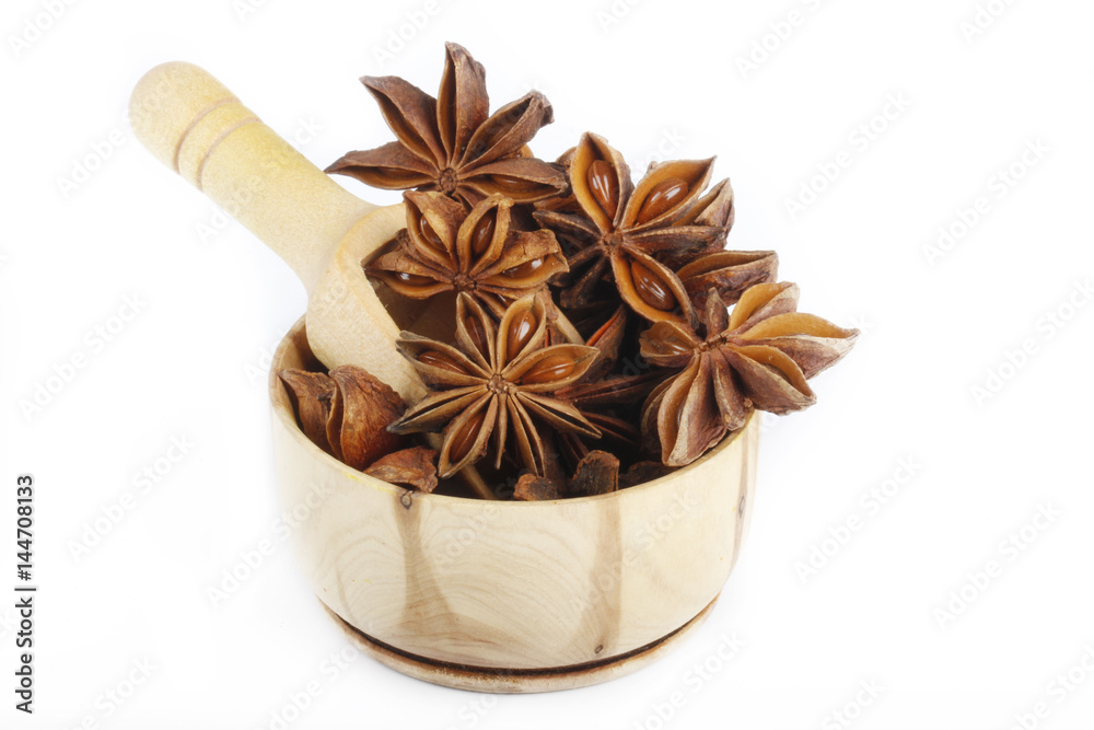 star anise (badian) in wooden cup isolated