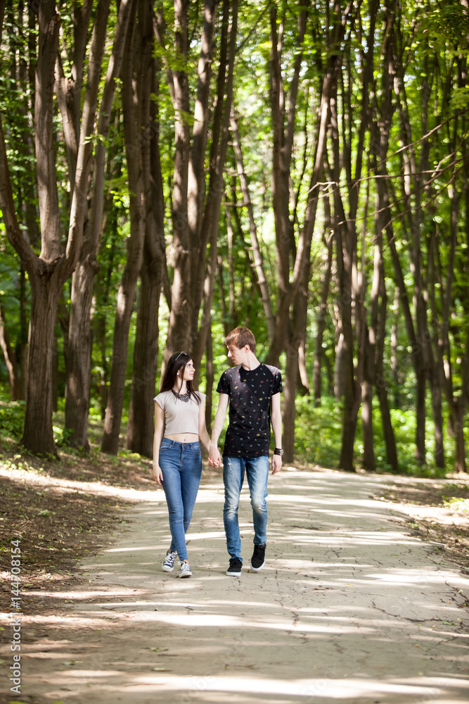 Happy couple taking a walk in the forest. Lifestyle and relationship. Young inlove boyfriend and girlfriend Happy couple taking a walk in the forest. Lifestyle and relationship. Young inlove boyfriend and girlfriend