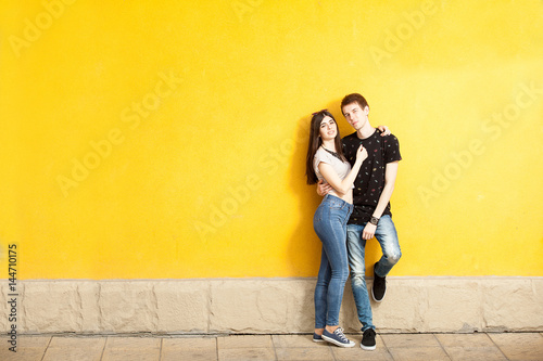 Inlove couple posing in fashion style on yellow wall. Lifestyle and relationship