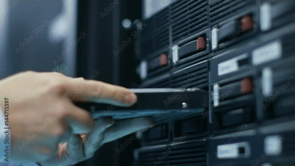 In Fully Working Data Center IT Engineer Installs Hard Drive into Server Rack. Detailed and Tehnically Accurate Footage. Shot on RED EPIC-W 8K Helium Cinema Camera.