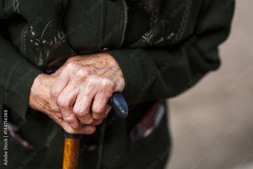 Old woman hand holding walking stick