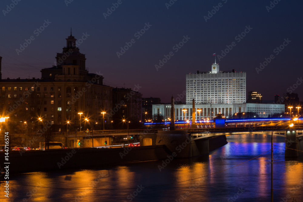 Fototapeta Night panorama of the House of Government of Russian Federation, bridges across the Moscow River and reflection in the river.