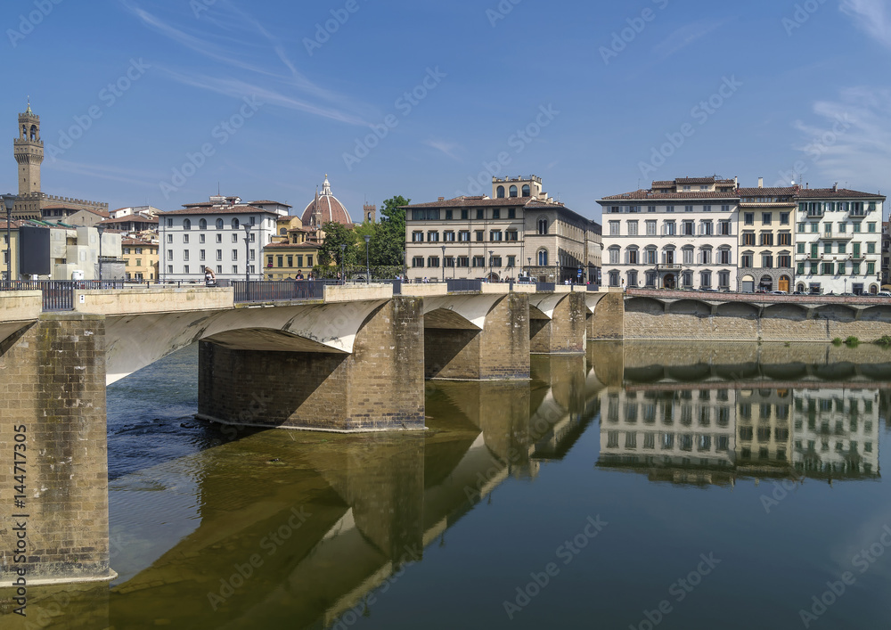The Ponte alle Grazie bridge is reflected in the Arno river which flows in the historic center of Florence, Italy, on a sunny day