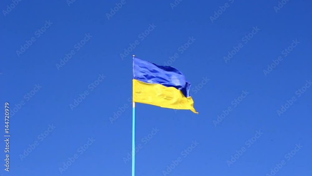 Yellow-blue flag of Ukraine against the sky, shimmering in the sun, fluttering in the wind. Yellow-blue flag of Ukraine against the sky, shimmering in the sun, fluttering in the wind.