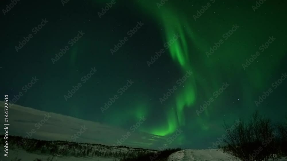 Northern lights Aurora borealis night stars sky. Northern pole winter snow cold. Green effect in the sky. Time-lapse slow movement beautiful color. Center of the storm 