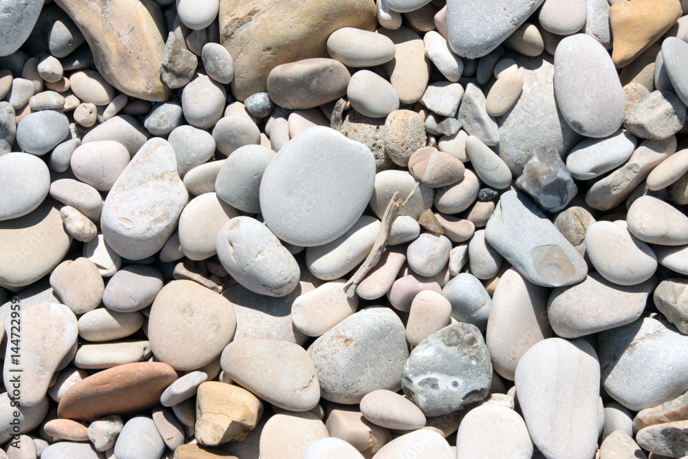 tanti sassi sulla spiaggia bagnata d'estate dal mare, con il sole che asciuga e leviga questi piccoli doni fino a farli diventare una sabbia finissima, biancheggiante e levigata tanti sassi sulla spiaggia bagnata d'estate dal mare, con il sole che asciuga e leviga questi piccoli doni fino a farli diventare una sabbia finissima, biancheggiante e levigata