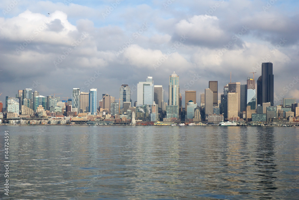 SEATTLE, WASHINGTON, USA - JAN 25th, 2017: A view on Seattle downtown from the waters of Puget Sound. Piers, skyscrapers, Space Needle and Ferris wheel in Seattle city before sunset