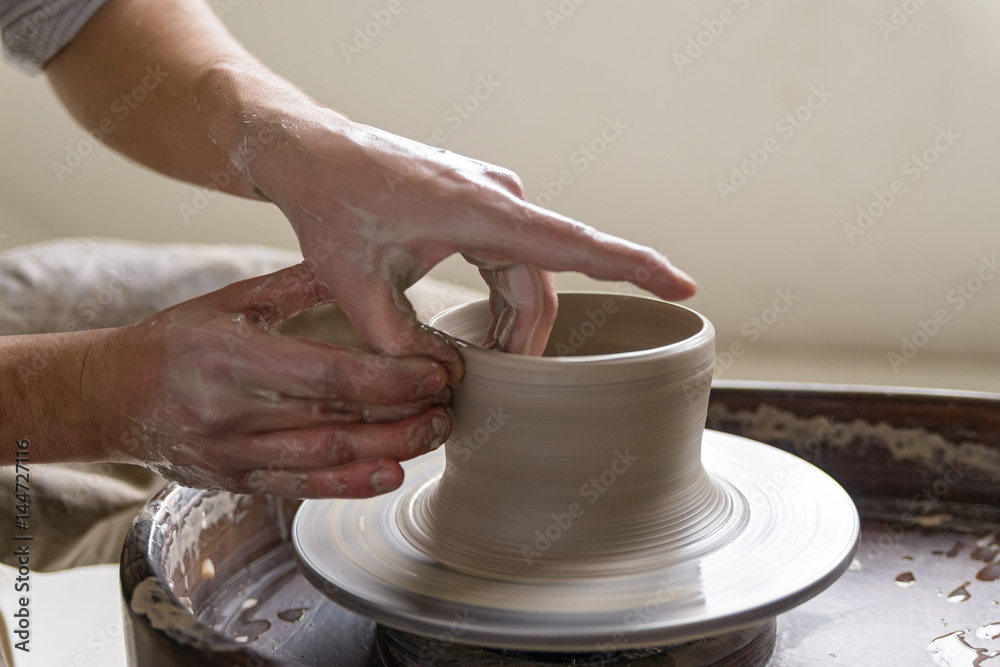 Hands working on pottery wheel Hands working on pottery wheel