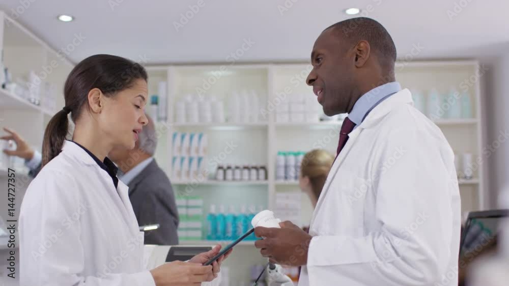 Workers having discussion & customers browsing in a chemist shop Workers having discussion & customers browsing in a chemist shop