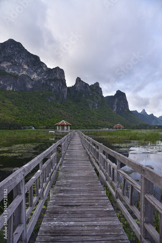 Old wooden bridge path to pavillion on lagoon. Beautiful tourist attractions Thailand