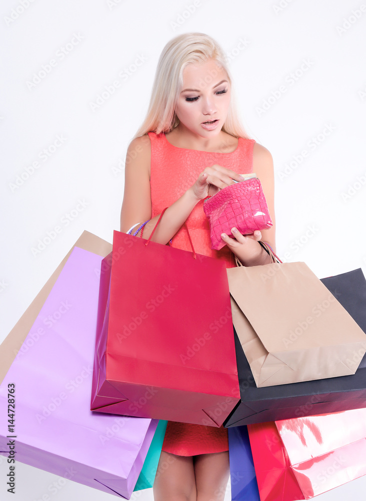 Luxury beautiful blonde girl or woman with clear skin and blue eyes in surprised shock about shopping. Empty wallet, spend all the money. Girl with bag success shopping, in orange dress Luxury beautiful blonde girl or woman with clear skin and blue eyes in surprised shock about shopping. Empty wallet, spend all the money. Girl with bag success shopping, in orange dress