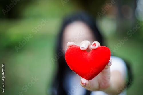 red heart in human hand with dramatic tone