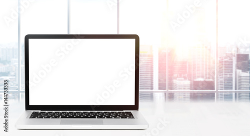 Laptop on table in office with panoramic view of modern downtown skyscrapers at business district