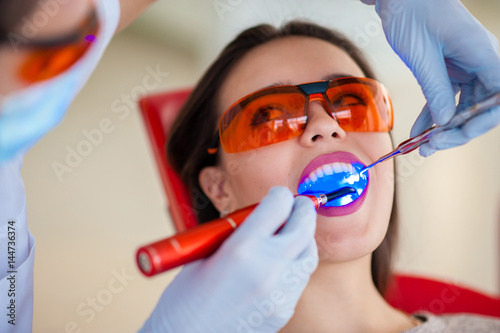Treatment of light seal beautiful girl in dentistry.