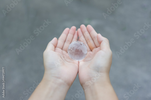 Woman holds glass earth in her hands. Globe