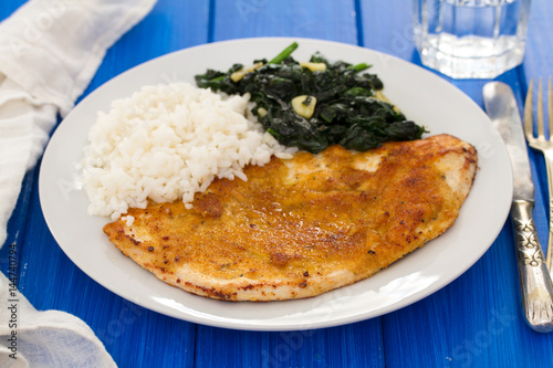 fried turkey with rice and spinach on the dish