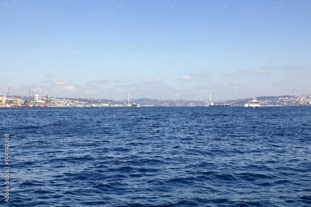 View of Bosphorus from public ferry. Ships, boats and bridge and blue sea are in the view.