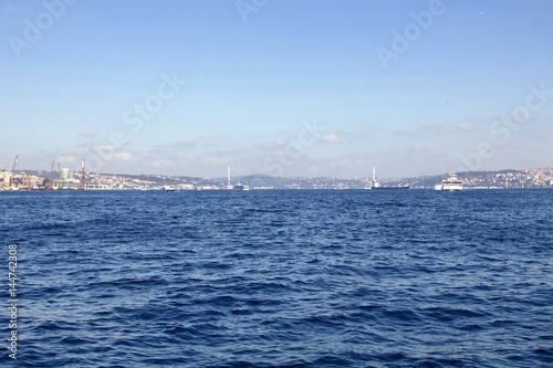 View of Bosphorus from public ferry. Ships, boats and bridge and blue sea are in the view. © theendup