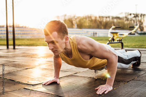 Man do workout at stadium area with sunshine background