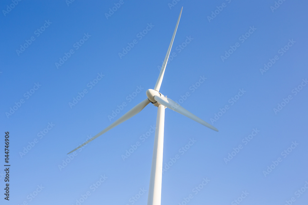 Wind turbine generating electricity with blue sky - energy conservation concept Wind turbine generating electricity with blue sky - energy conservation concept