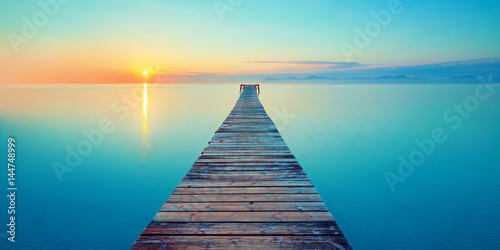 Holz Steg Brücke mit See und Sonnenaufgang photo