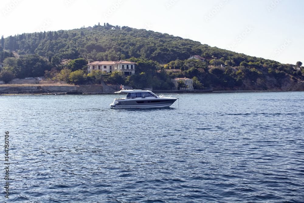Small yacht passes by Haybeliada which is one of Prince Islands in Istanbul.