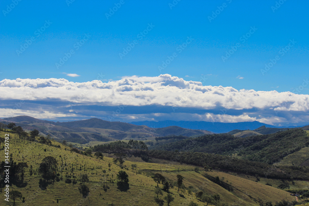 Landscape of range of mountains with blue sky and clouds