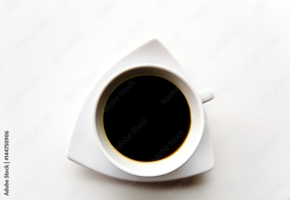 Black coffee in a white cup on a white saucer.